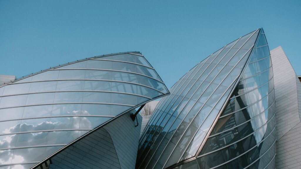 Sleek modern building with glass and steel facade, showcasing contemporary architecture.